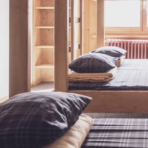 Multi-bed room with double bunk beds and clothes racks  | © Davos Klosters Mountains 