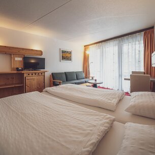 Room with double bed, sofa and coffee table  | © Davos Klosters Mountains 