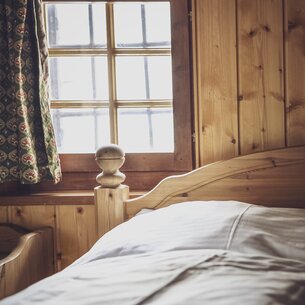 Hotel bed with small window | © Davos Klosters Mountains